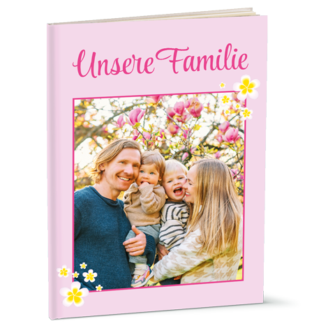 Ein Familienbuch mit einem Foto von Eltern und zwei Kindern vor blühenden Magnolien.