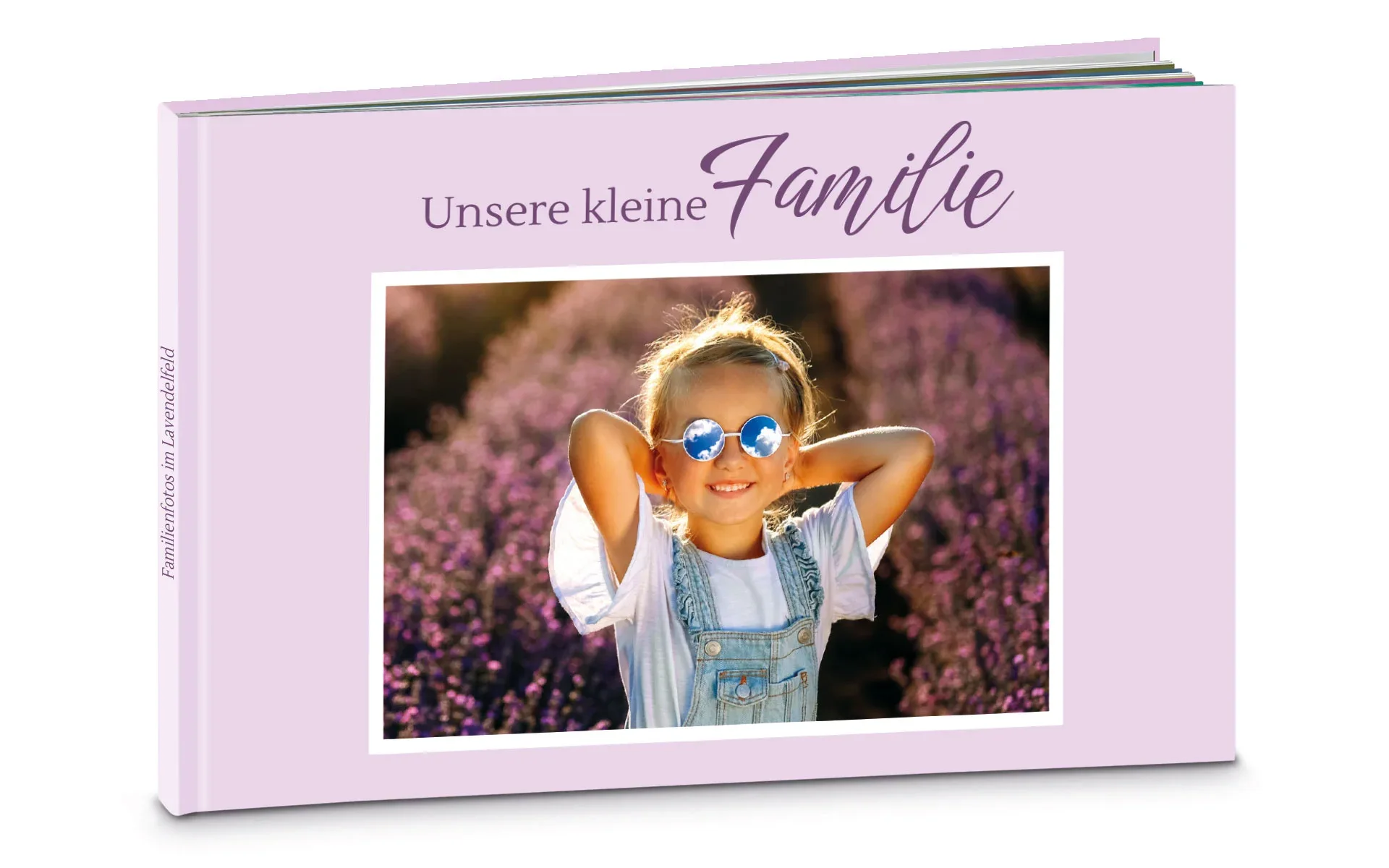 Ein aufgestelltes Happy Fotobuch ca. A4 quer mit dem Titel Unsere kleine Familie zeigt ein Mädchen in einem Lavendelfeld.