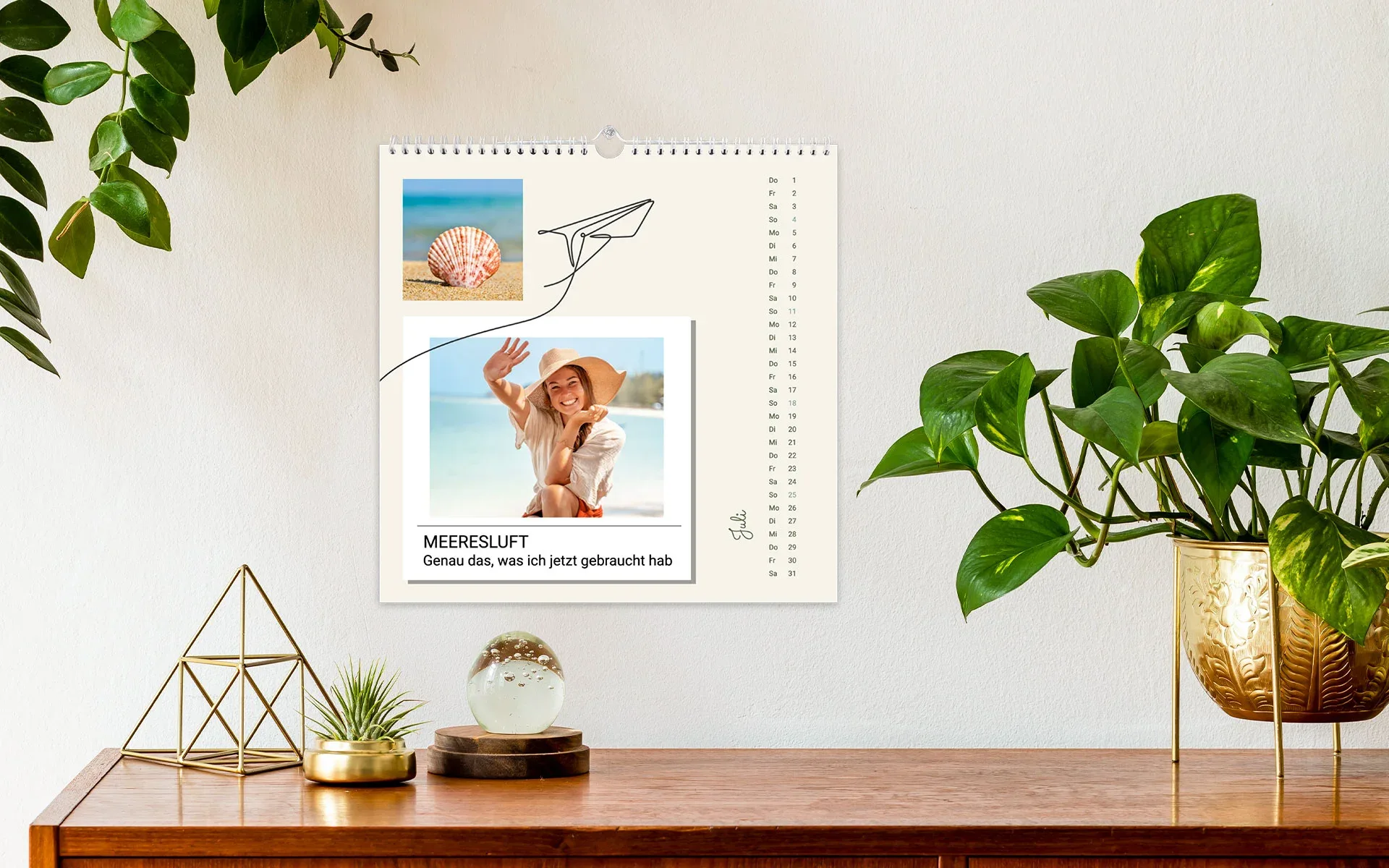 HappyFotokalender ca. 21 x 21 cm - aufgehängt Ein aufgehängter HappyFotokalender ca. 21 x 21 cm mit dem Text Meeresluft zeigt eine junge Frau am Strand.