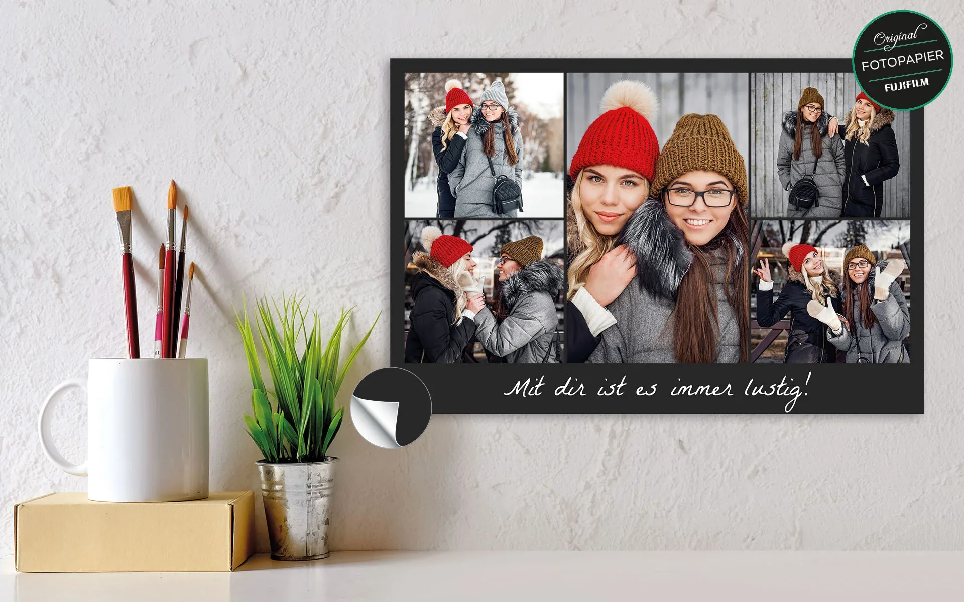Fotocollage ca. 30 x 45 cm - aufgehängt Eine aufgehängte Fotocollage ca. 30 x 45 cm mit dem Text Mit dir ist es immer lustig zeigt 5 Fotos zweier Freundinnen vor schwarzem Hintergrund.